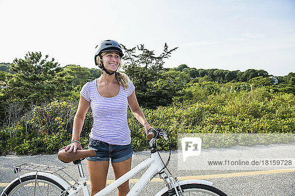 Smiling Woman biking on Cape Cod bike path in summer