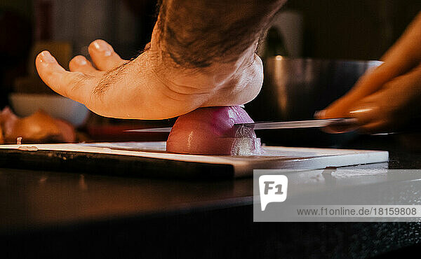 Man cutting onion in a kitchen