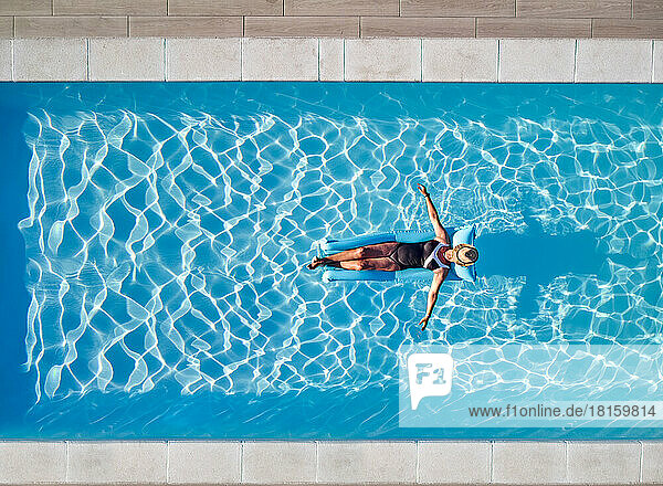 Frau schwimmt auf Schlauchboot im Pool