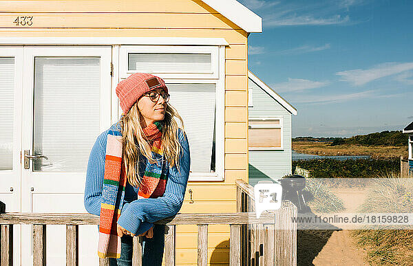 woman enjoying the sea breeze and sunshine at a beach hut