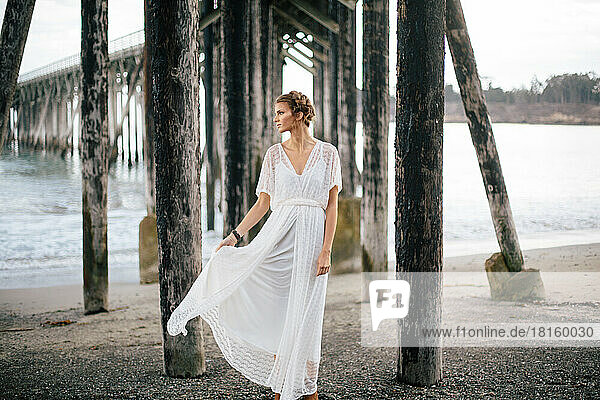 Vintage-Braut posiert am Strand in geschnürtem Hochzeitskleid in Muir Woo