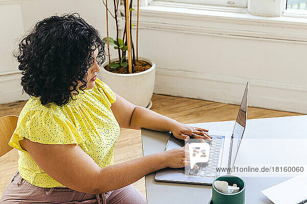 High angle view of female entrepreneur typing on laptop