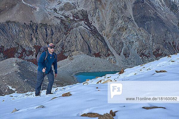 man alone climbing a snowy mountain in patagonia argentina