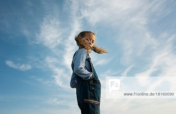 Porträt eines Mädchens  das mit wehendem Haar im Wind steht