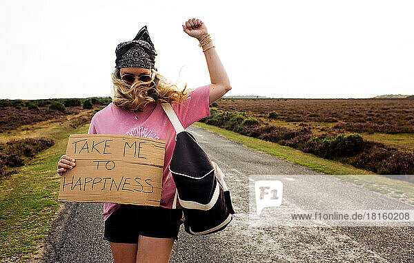 Frau protestiert mit einem Schild mit der Aufschrift Take me to happiness