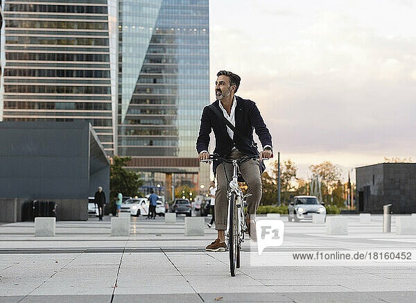 Pendler überquert die Straße und fährt mit dem Fahrrad in der Stadt