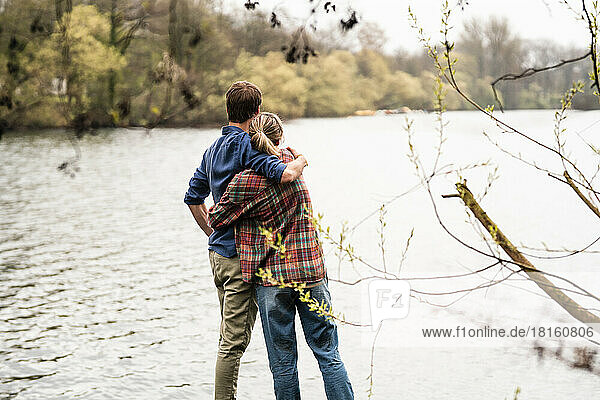 Couple embracing each other looking at lake