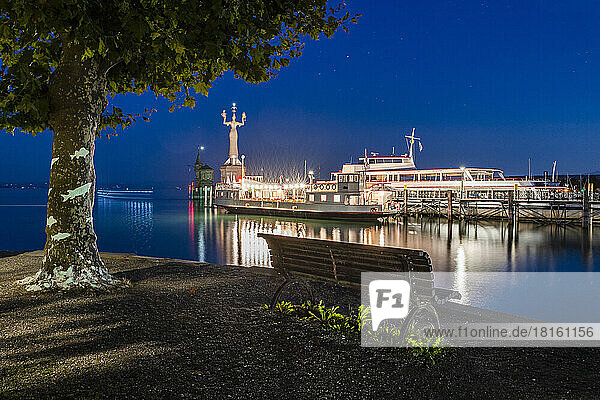 Germany  Baden-Wurttemberg  Konstanz  Harbor on shore of Lake Constance at night with empty bench in foreground