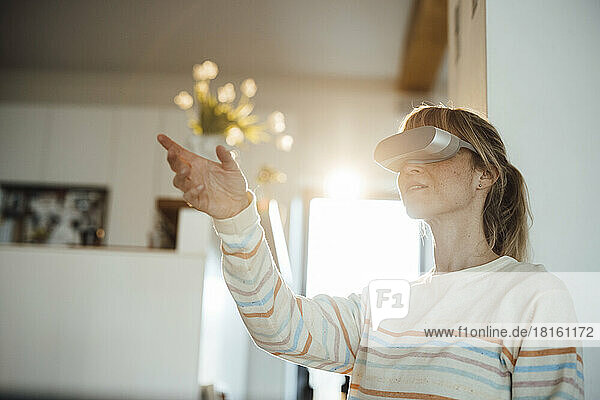Woman having fun wearing virtual reality headset at home