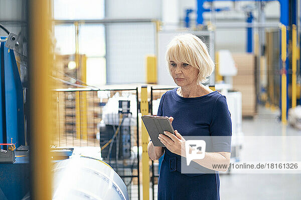 Senior businesswoman using tablet PC in industry