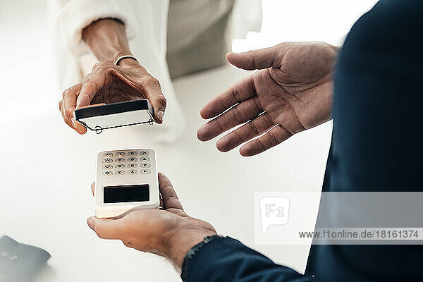 Mature woman doing mobile payment through smart phone