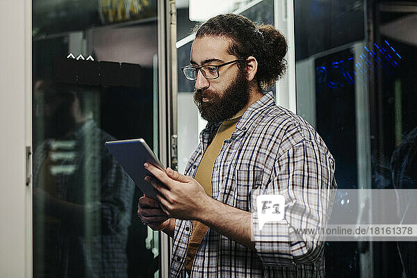 Computer technician holding tablet PC in server room