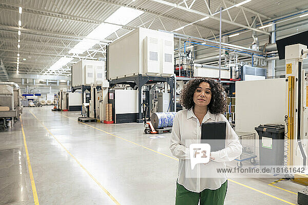 Businesswoman holding laptop in industry