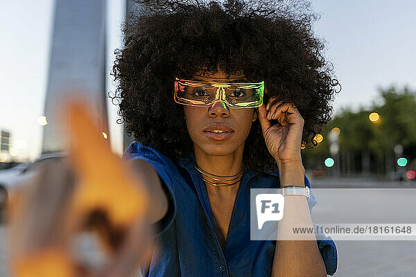 Afro-Frau trägt in der Abenddämmerung eine intelligente Brille