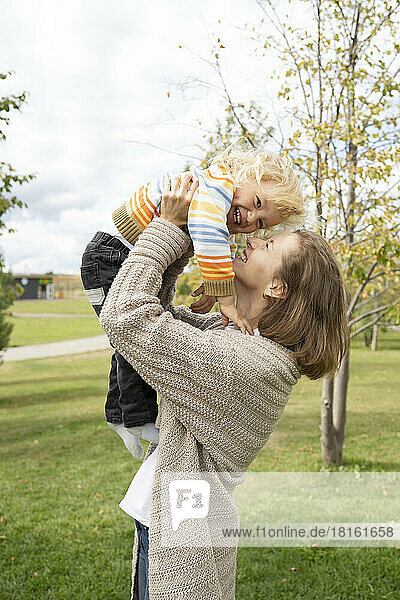 Cheerful mother playing with son in park