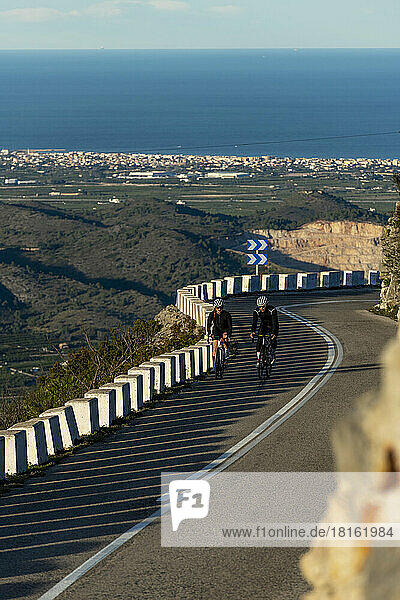 Sportsman and sportswoman cycling on mountain pass  Alicante  Spain