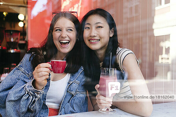 Multiracial lesbian couple enjoying drinks at cafe