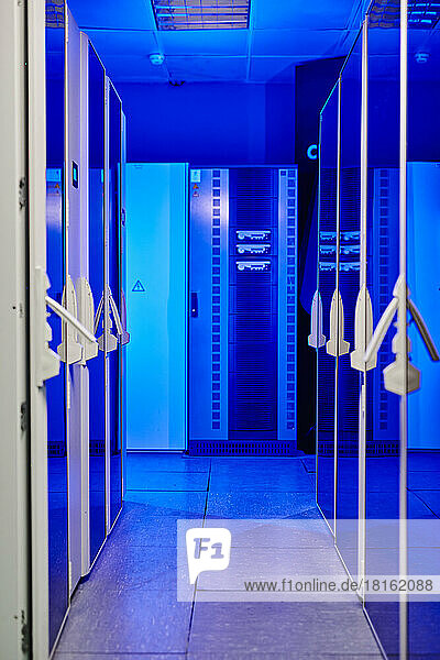 Corridor of illuminated server room with blue neon light