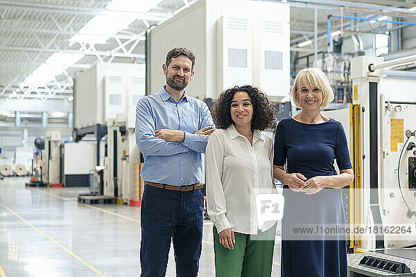 Smiling senior businesswoman with colleagues in industry