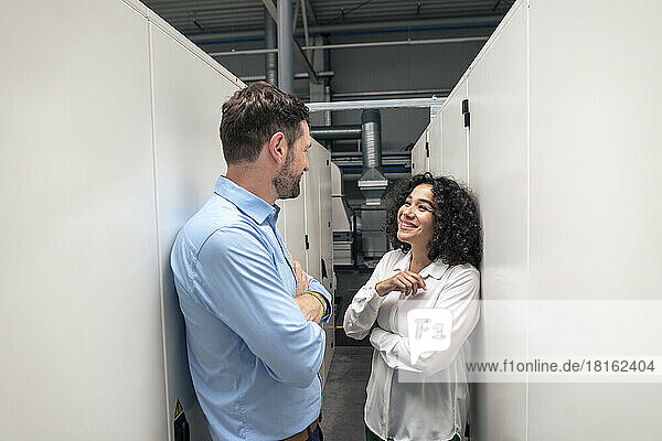 Happy businesswoman discussing with colleague in industry