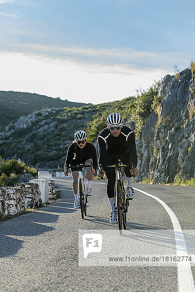 Sportsman and sportswoman cycling on Costa Blanca mountain pass in Alicante  Spain