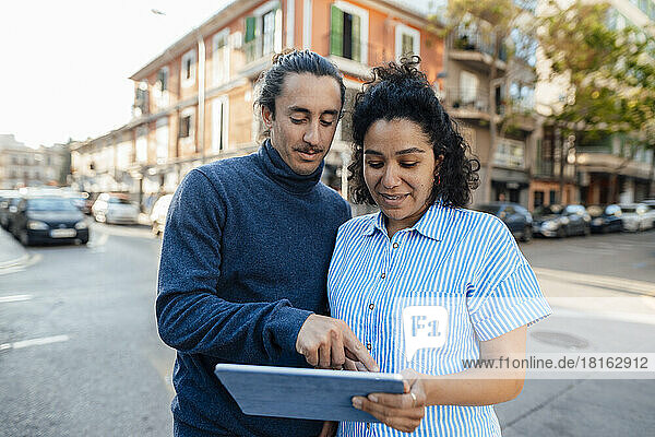 Freelancers using tablet PC together on road