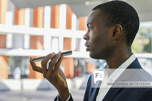 Young businessman talking on mobile phone at railroad station