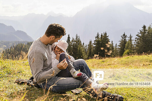 Playful father with daughter in meadow