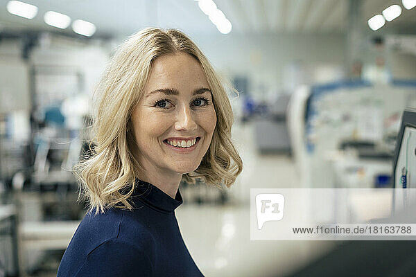 Happy businesswoman with blond hair at industry