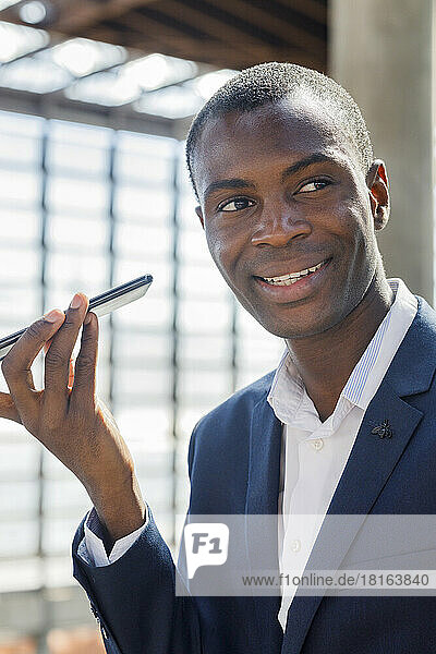 Happy young businessman talking on smart phone