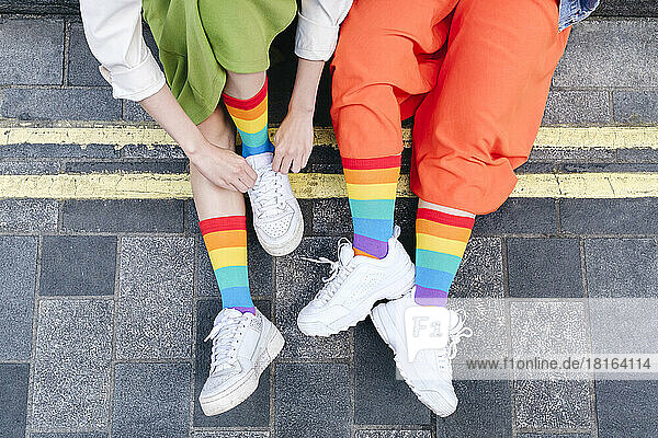 Junges lesbisches Paar trägt bunte Socken am Fußweg