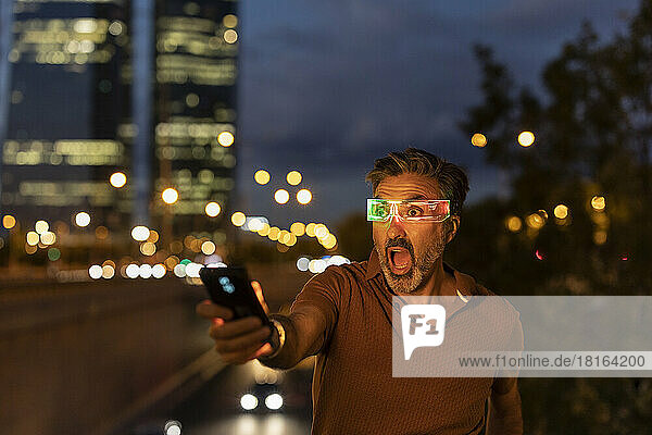 Shocked businessman wearing smart glasses at night