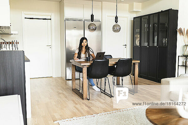 Young businesswoman working on laptop at home