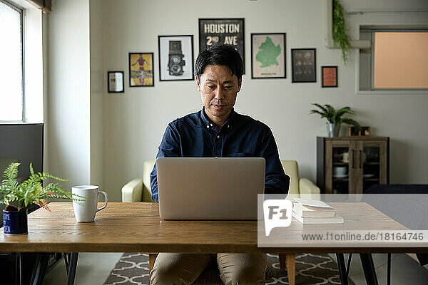 Japaner arbeitet von zu Hause aus am Laptop