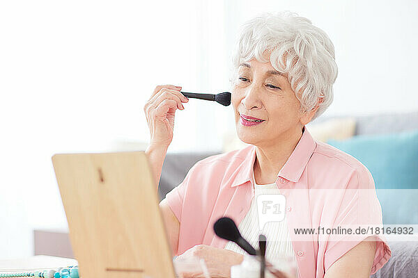 Japanische Seniorin beim Schminken