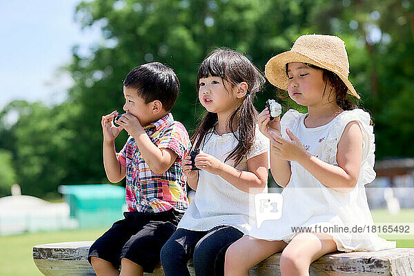 Japanese kids eating at a city park
