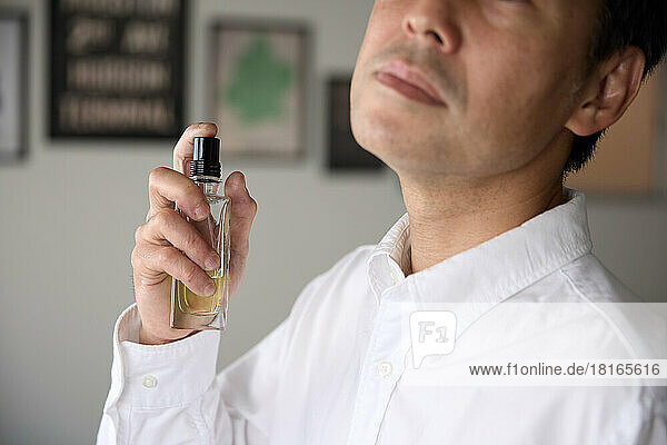 Japanischer Mann trägt Parfüm