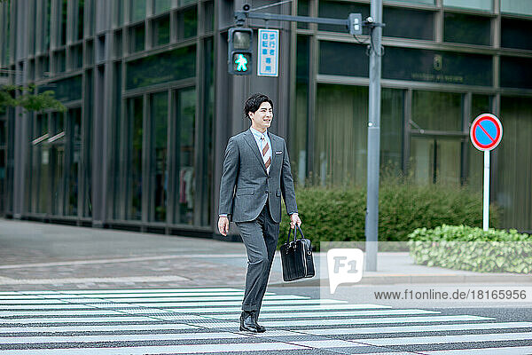 Japanischer Geschäftsmann zu Fuß