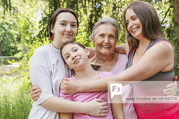 Happy senior woman with family standing together at park
