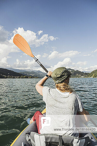 Woman kayaking at lake on sunny day
