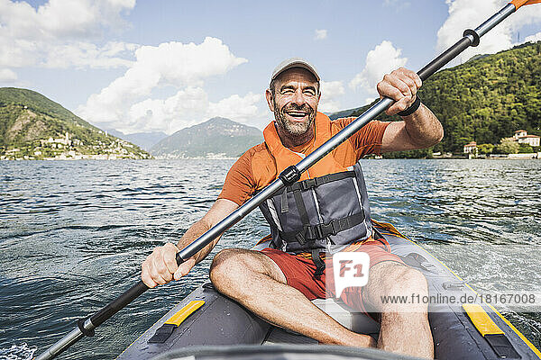 Fröhlicher reifer Mann genießt Kajakfahren am See