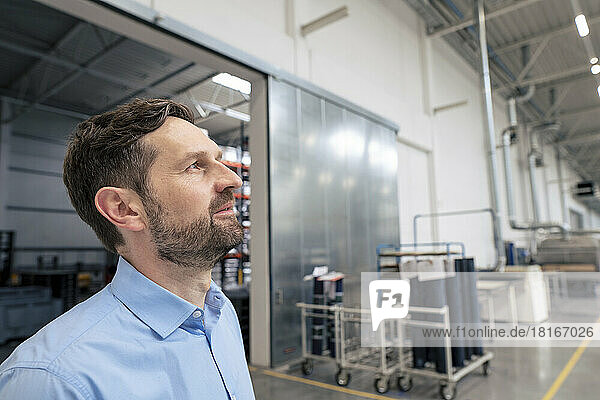 Thoughtful businessman in factory hall
