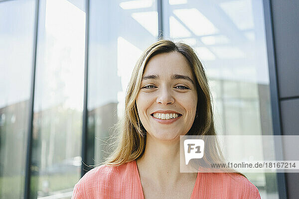 Happy woman in front of glass wall