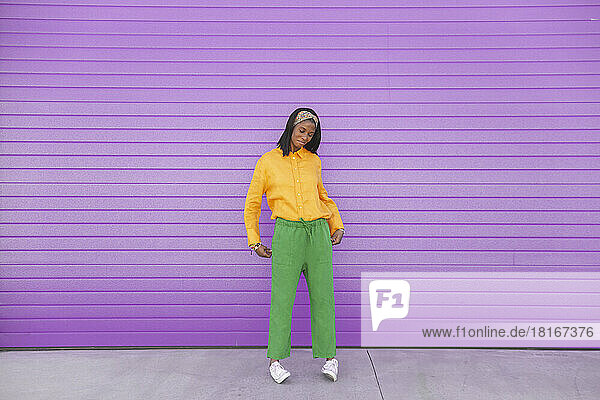 Young woman standing in front of purple wall