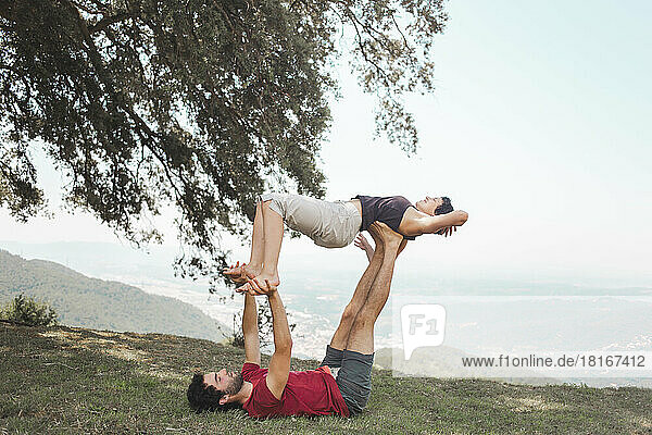 Junges Paar praktiziert Yoga auf dem Berggipfel