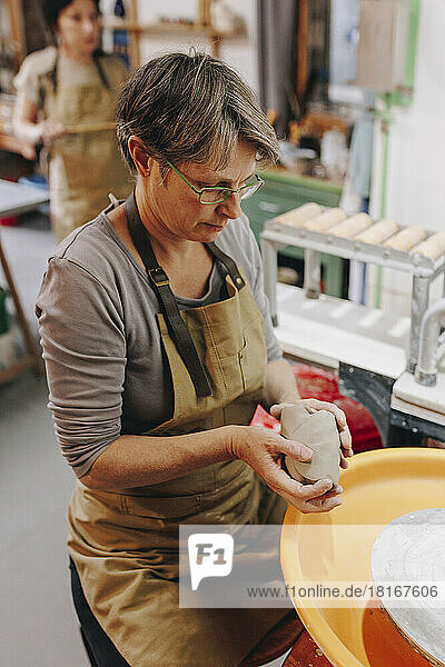 Töpfer arbeitet mit Ton in der Keramikwerkstatt