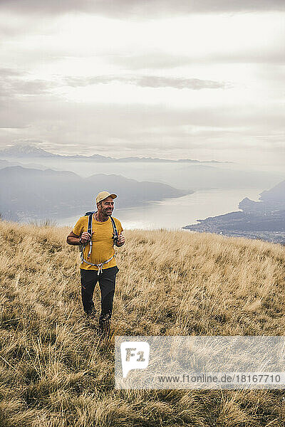 Smiling man wearing cap hiking on mountain