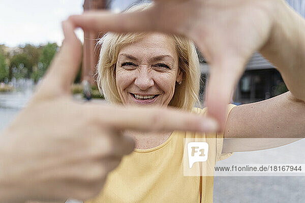 Happy mature woman making finger frame