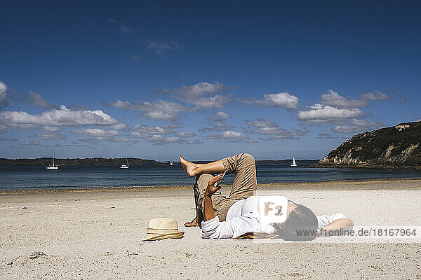Frau benutzt Mobiltelefon und entspannt sich an einem sonnigen Tag am Strand