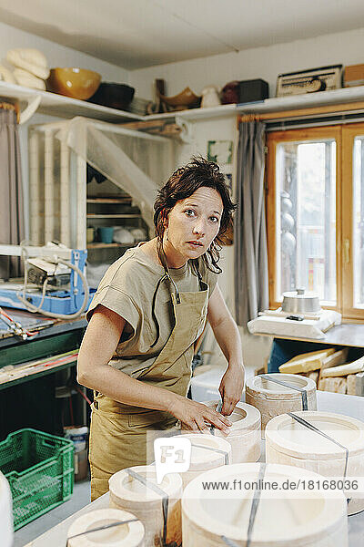 Unternehmer bindet in der Werkstatt Schnur an Keramik